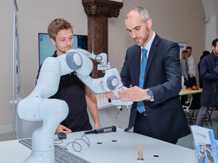 Zwei M&auml;nner mit Industrieroboter